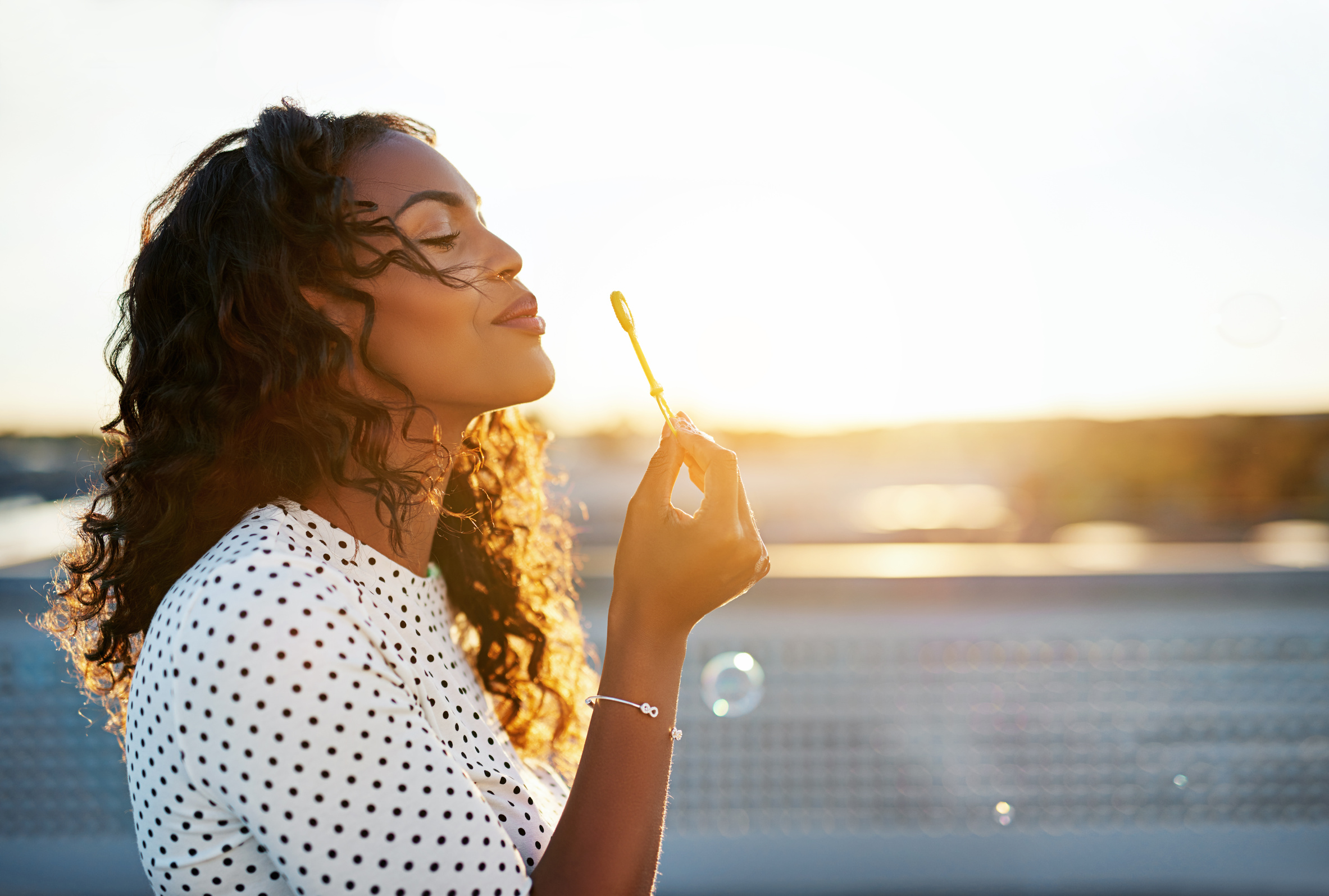 Woman Blowing Bubbles Outdoors